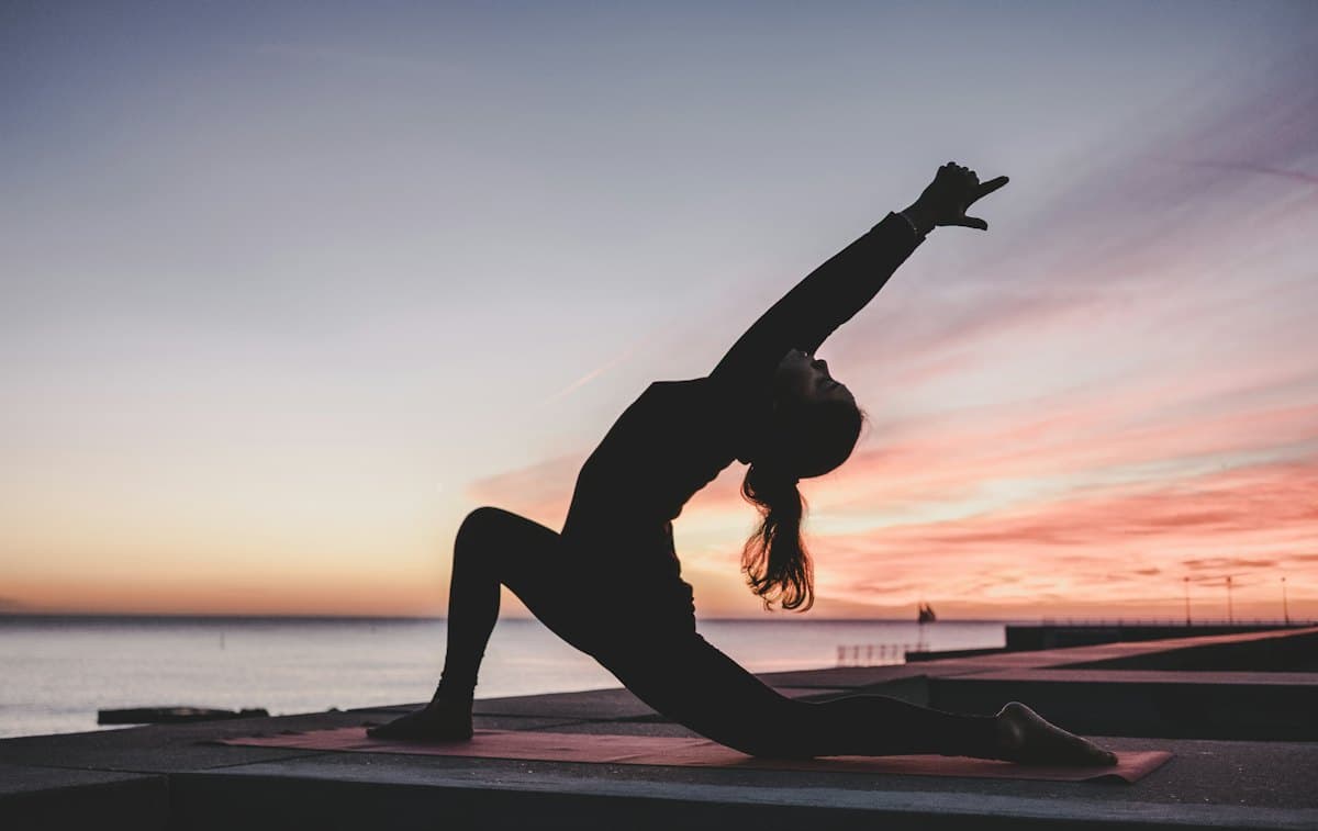 A person flowing through a dynamic yoga sequence in warm light